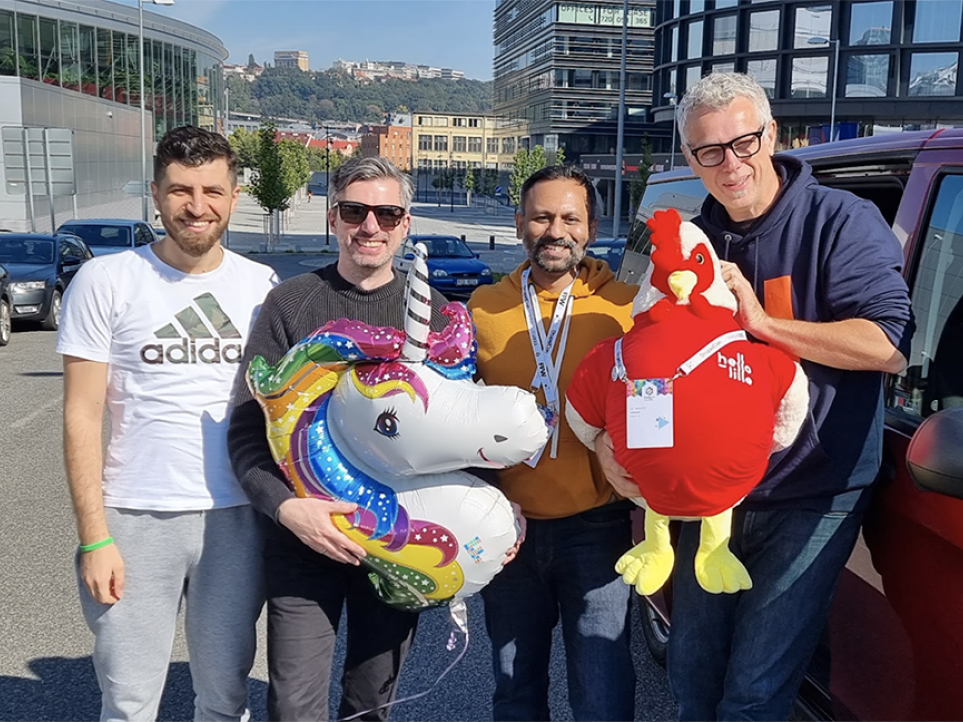 Factorial team on their visit to DrupalCon Prague 2022, holding the lille rooster mascot.