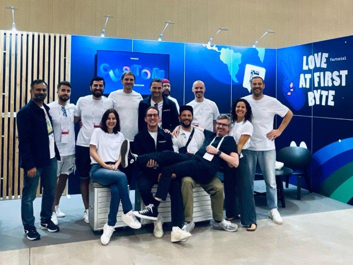 Factorial Team at DrupalCon Barcelona 2024 in front of their event booth.