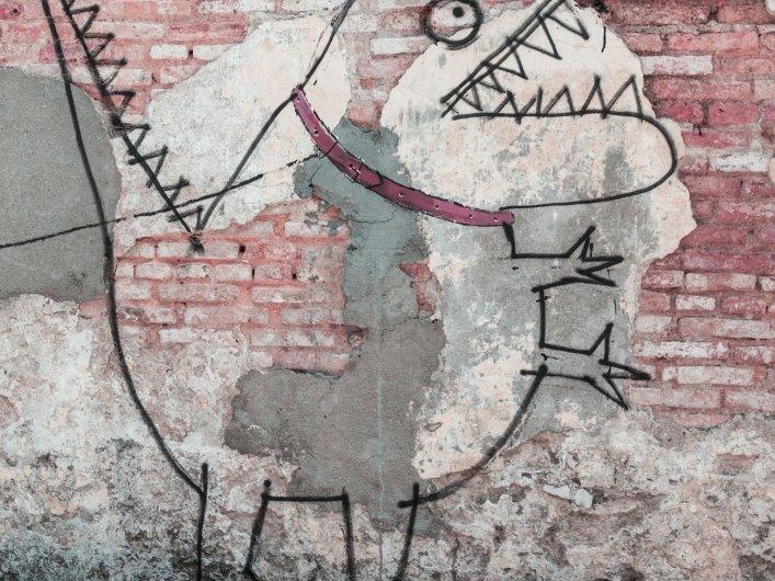 Streetart an Mauer, zu sehen ist ein Kind, dass ein Monster an der Leine hält