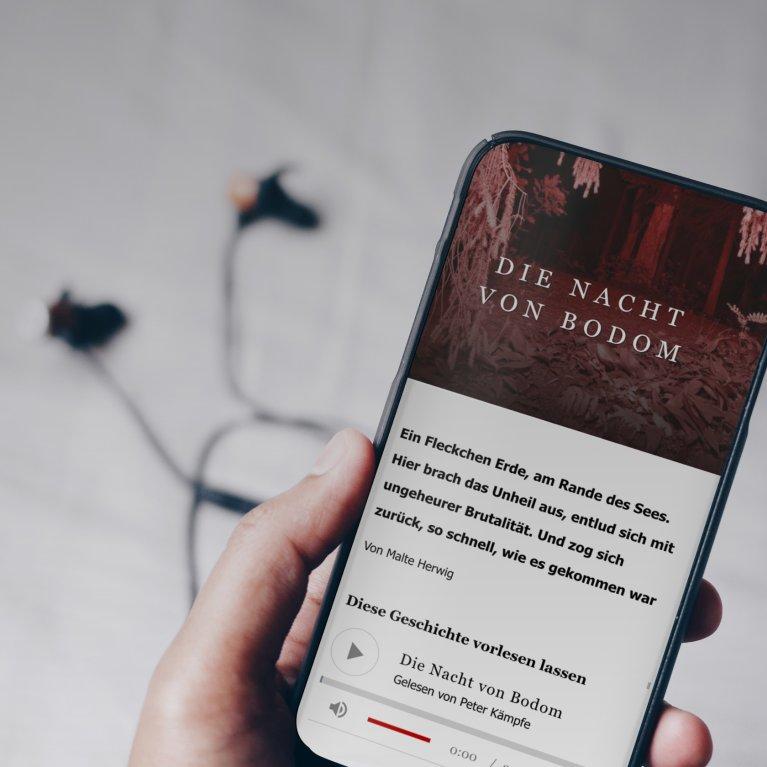Eine Hand hält ein Smartphone, auf dem ein Artikel inkl. Vorlesefunktion zu sehen ist