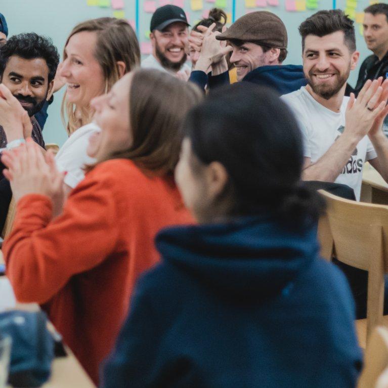Menschen, die bei einer internen Factorial-Veranstaltung Spaß haben und jubeln