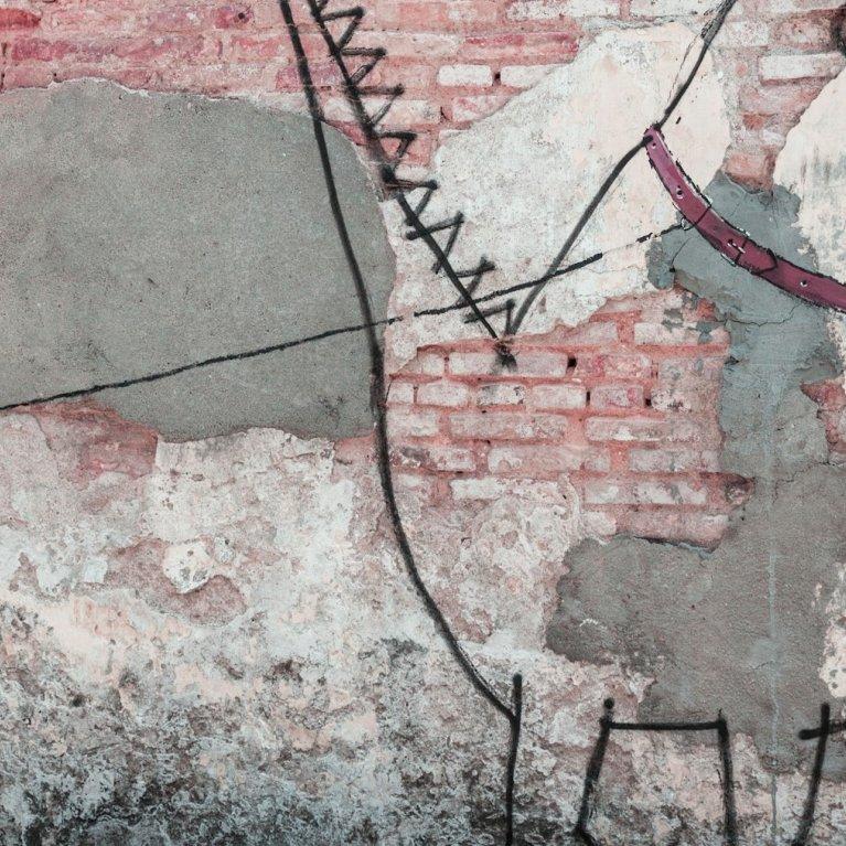 Streetart an Mauer, zu sehen ist ein Kind, dass ein Monster an der Leine hält
