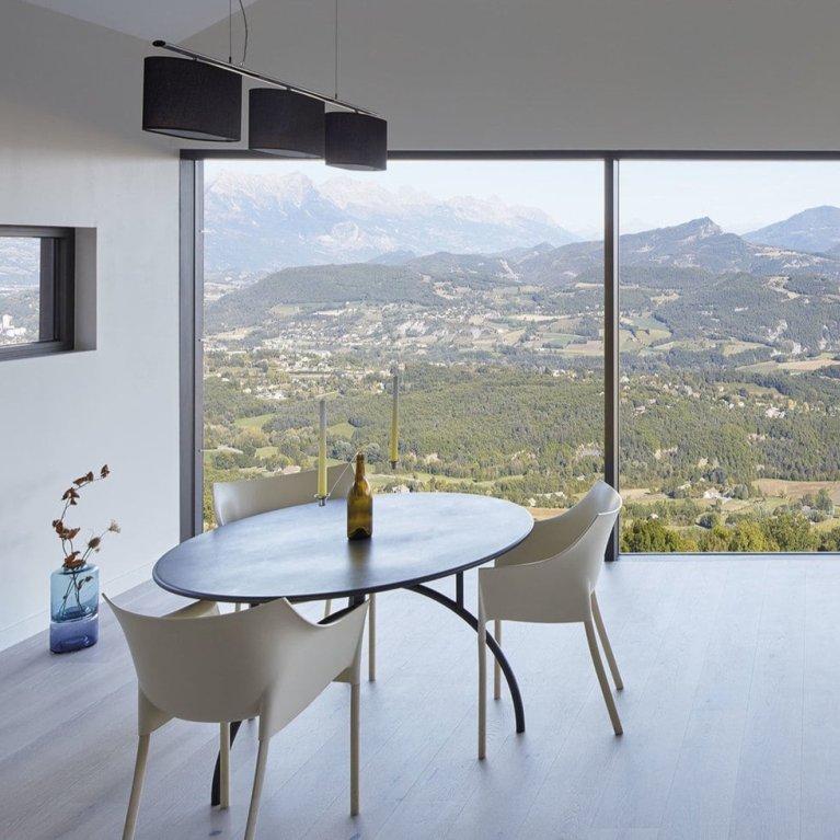 Bild eines Zimmers mit Fensterfront und einer Landschaft im Hintergrund