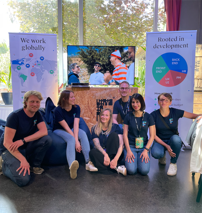 Image showing a group picture of the factorial team at their expo booth during Beyond Tellerrand conference 2022 in Berlin.