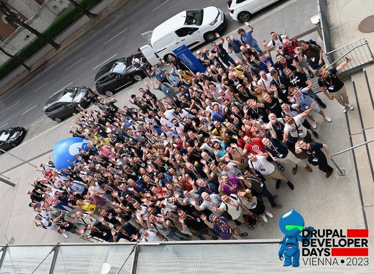 Gruppenfoto der Teilnehmer der Drupal Developer Days 2023 in Wien, lächelnd und posierend vor einem Veranstaltungsort.