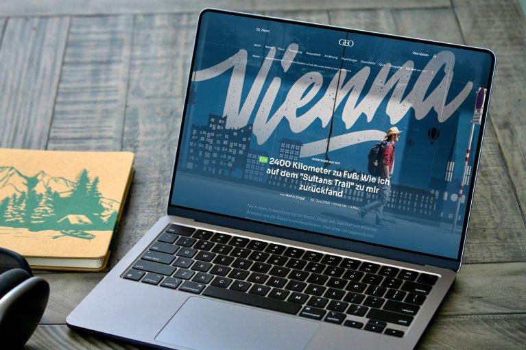 Laptop, der die GEO-Website mit einem Artikel über die Stadt Wien auf dem Display zeigt.