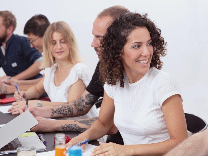 Unsere Mitarbeiterin Seda im Vordergrund. Im Hintergrund sind verschwommen weitere Kollegen zu sehen.