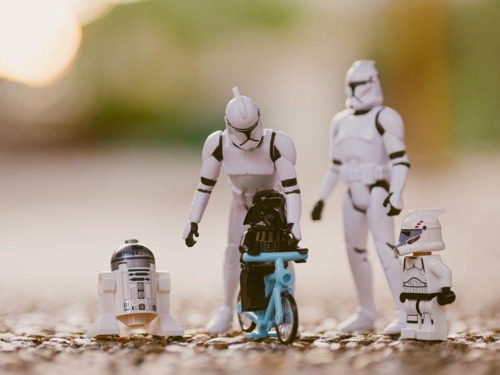 Eine Sammlung von Star-Wars-Figuren, die neben einem bunten Fahrrad ausgestellt ist, symbolisiert die berufliche Entwicklung und das berufliche Wachstum.